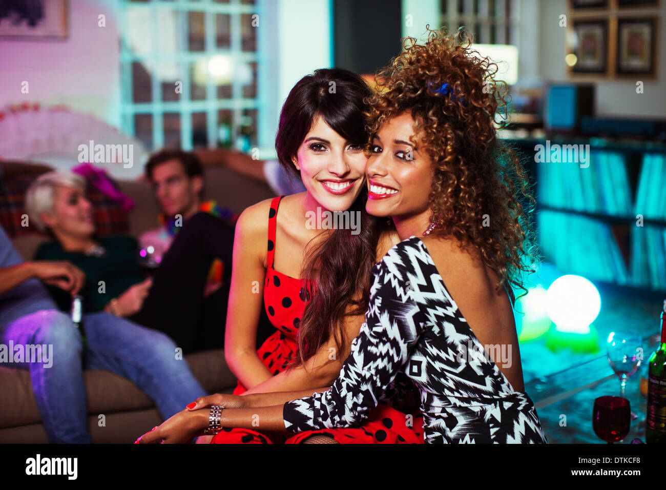 Donne abbracciando in salotto a parte Foto Stock