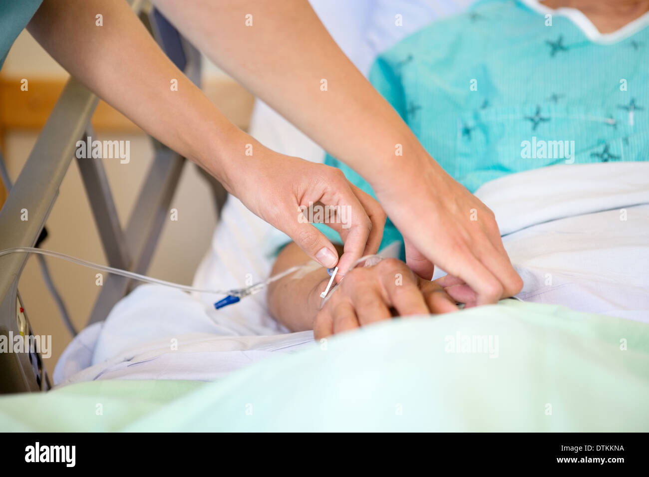 Fissaggio infermiere flebo IV maschio sulla mano del paziente Foto Stock