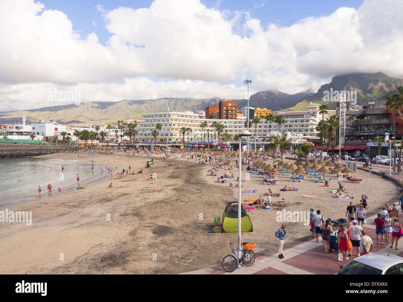 Puerto Colon spiaggia di Playa de las Americas Tenerife Spagna, turisti, lucertole da mare, passeggini godendo di una popolare destinazione Foto Stock
