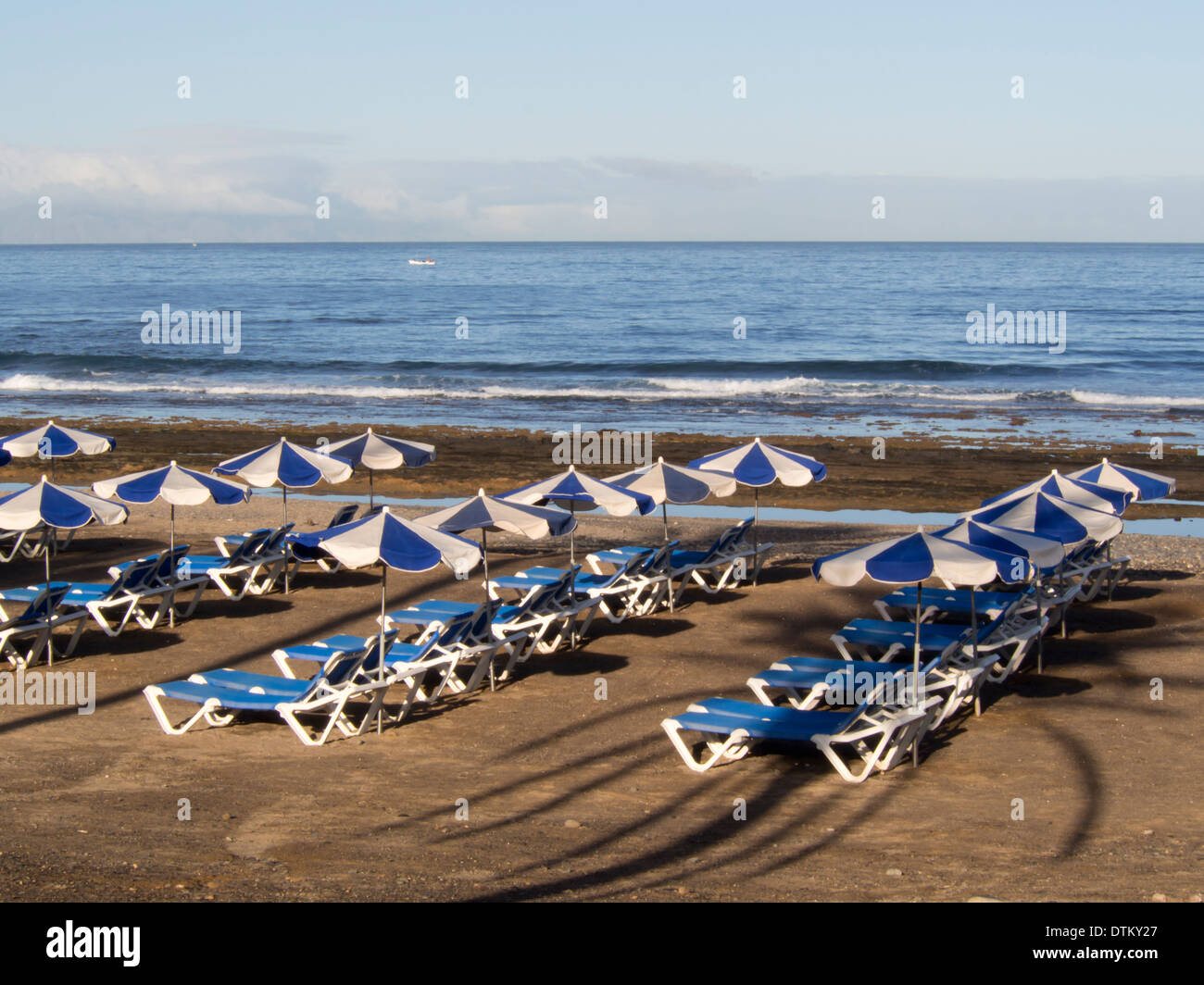 Mattina sulle spiagge di Playa de las Americas Tenerife Spagna lettini e ombrelloni pronti per il turista inset Foto Stock