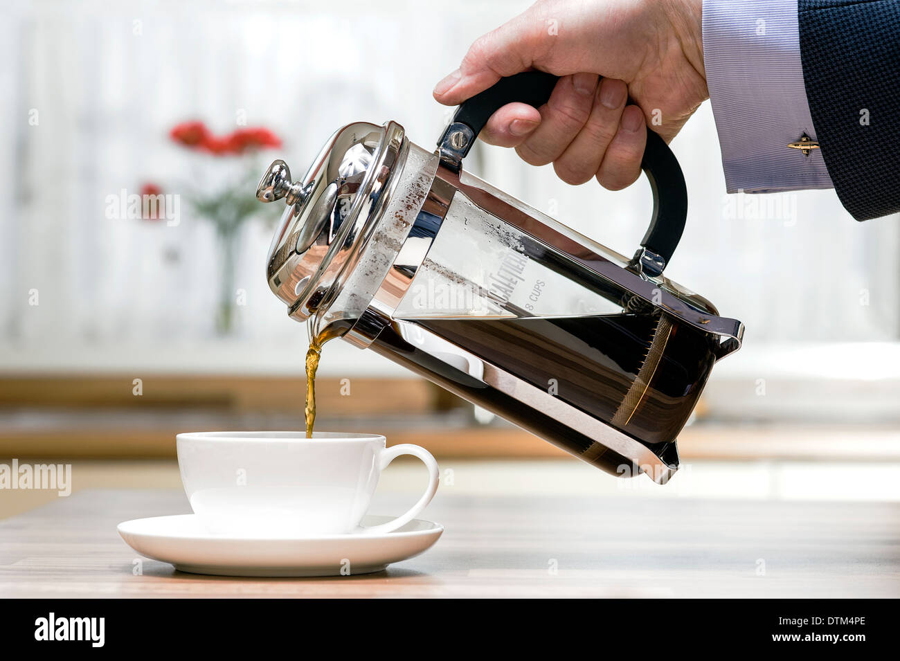 Imprenditore versando un caffè al mattino. Foto Stock