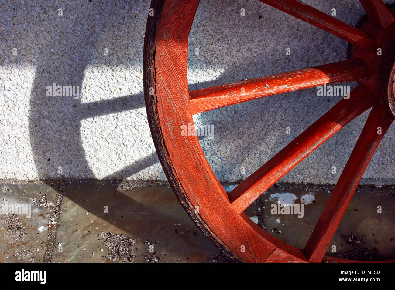 Un rosso ruota carrello getta un' ombra contro una parete dell'isola di Lewis, Ebridi Esterne, Scozia Foto Stock