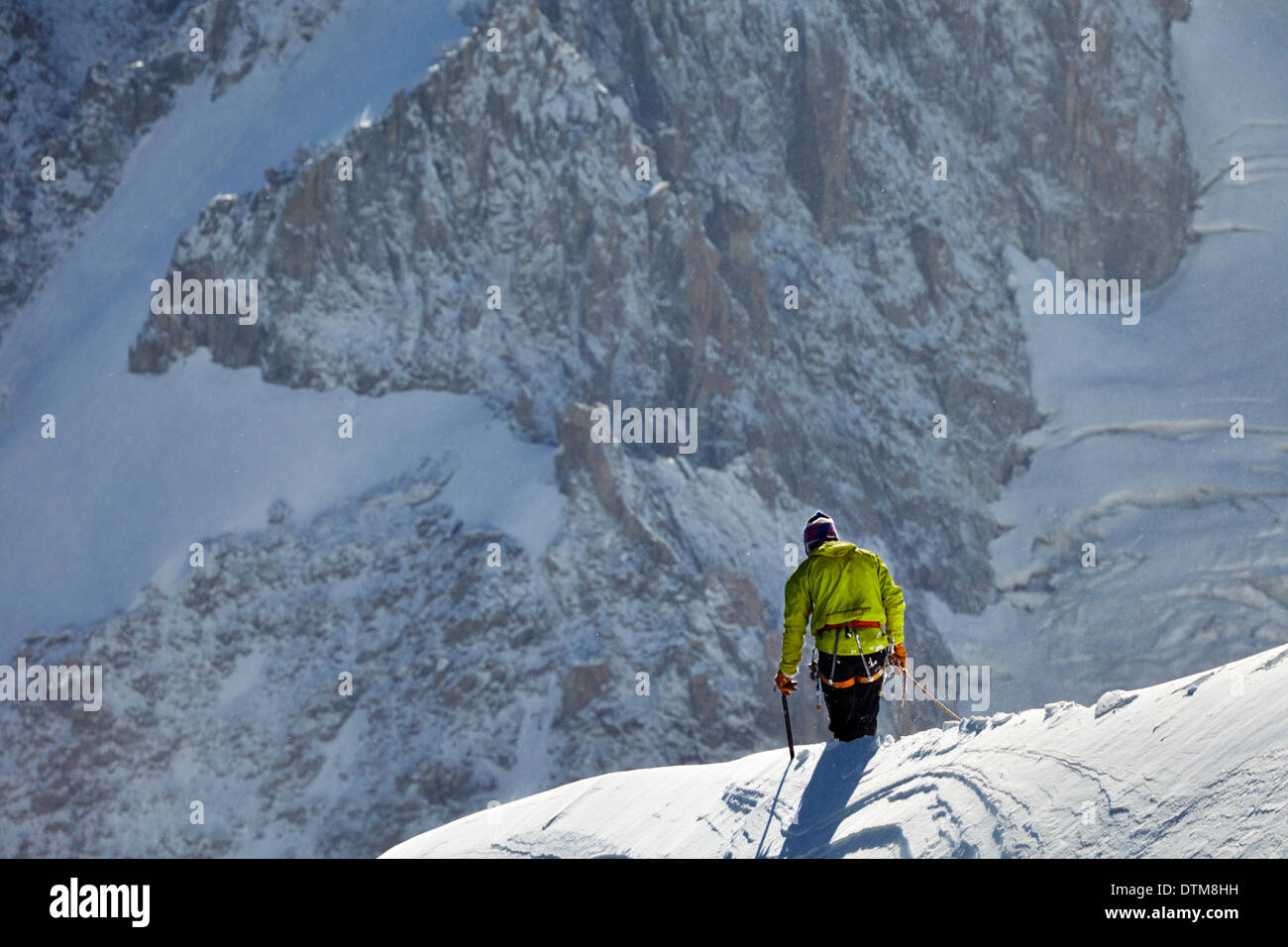 Lone scalatore attraversando una cresta sotto il Mont Blanc, alta sopra la valle di Chamonix nelle Alpi francesi. Foto Stock