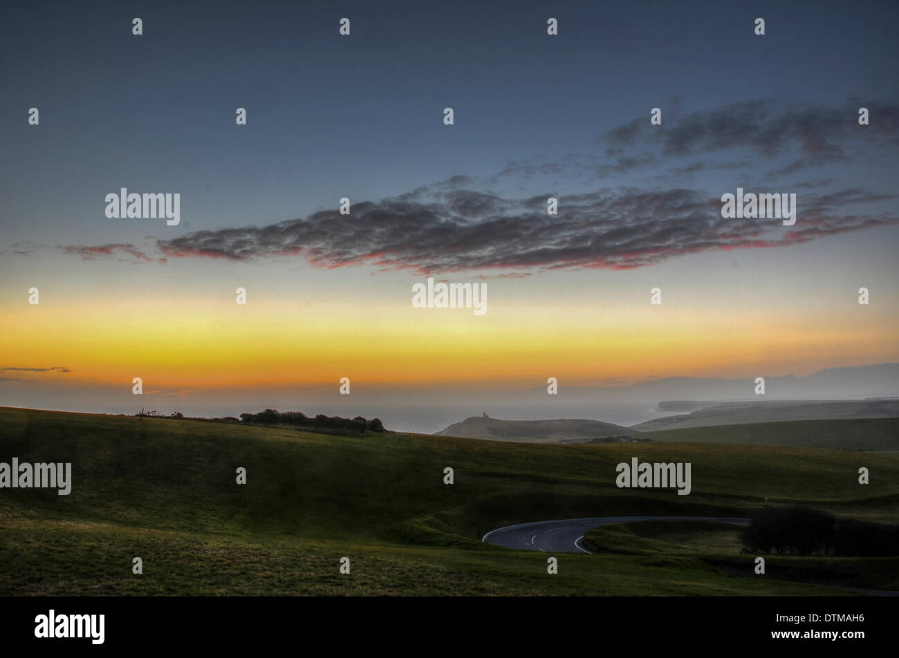 Beachy Head, East Sussex, Regno Unito. Xx Febbraio 2014. Pochi istanti dopo il tramonto sotto la nuvola sul mare da Beachy Head. La caduta di temperatura come cloud si disperde. Guardando verso Birling Gap e Sette sorelle, Belle Tout appena a destra del centro. Credito: David Burr/Alamy Live News Foto Stock