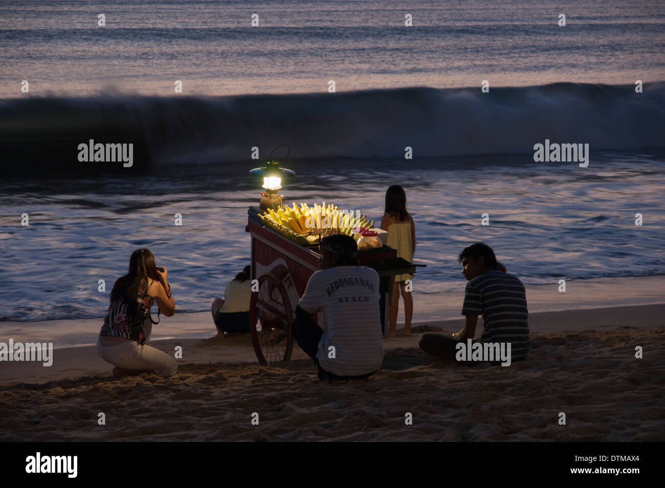 Piano di cottura di mais venditore su Jimbaran Beach nel tardo la luce del tramonto, Bali, Indonesia Foto Stock