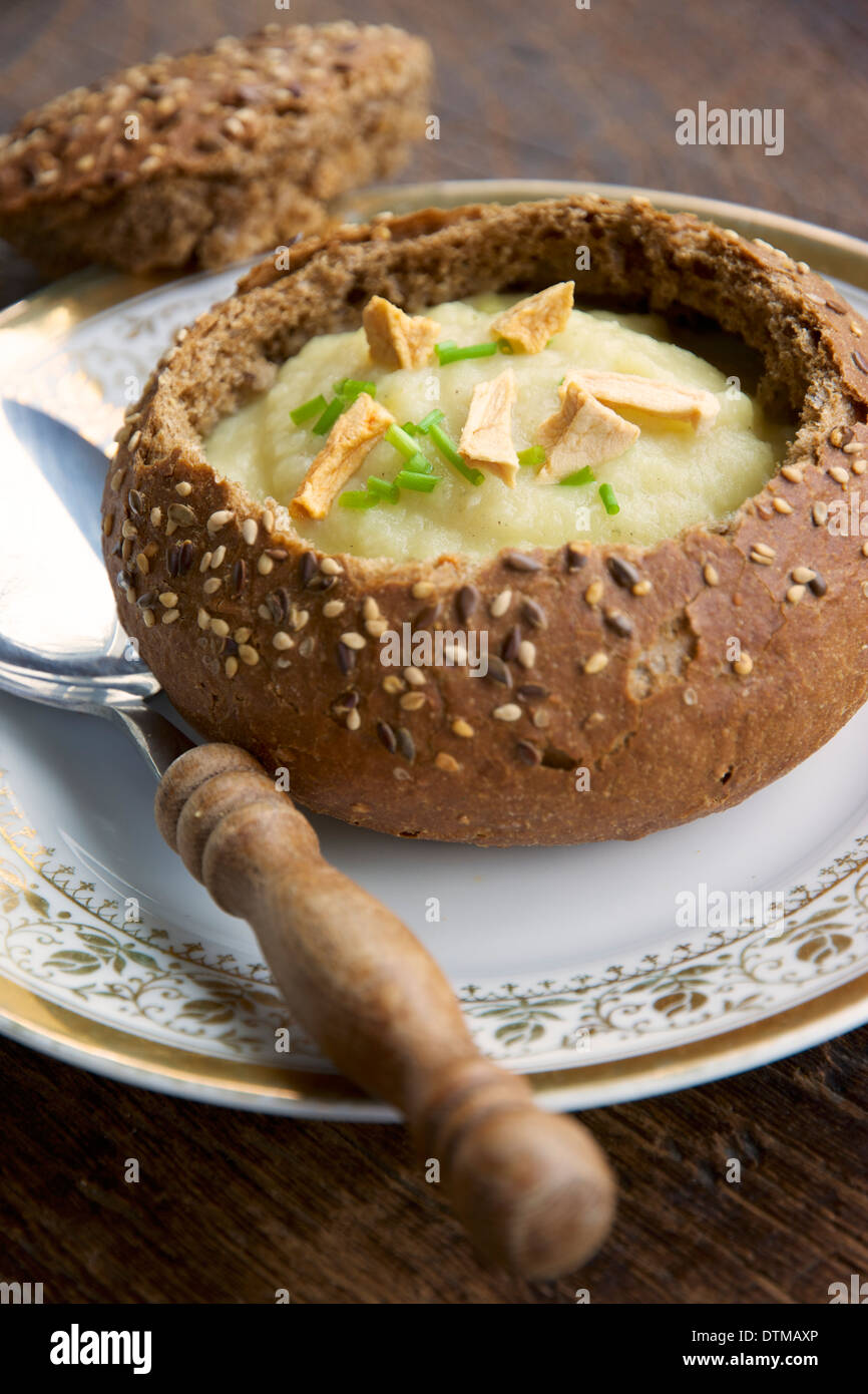 Apple pastinaca zuppa in una ciotola di pane, guarnita con secchi pezzi di Apple e di erba cipollina. Foto Stock