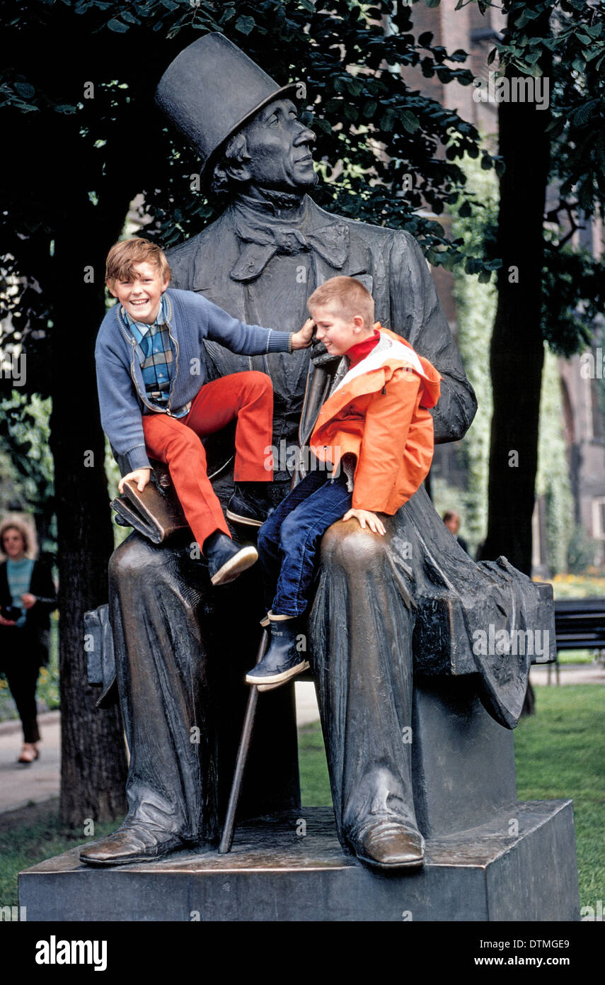 Due ragazzi di sedersi su un più grande del vita statua in bronzo di autore danese e poeta Hans Christian Andersen al di fuori del Municipio di Copenhagen, Danimarca. Foto Stock