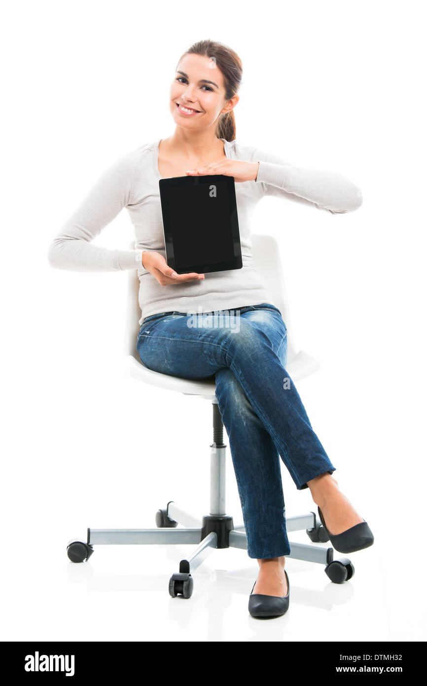 Bella studentessa seduto su una sedia che mostra qualcosa su un tablet, isolato su uno sfondo bianco Foto Stock