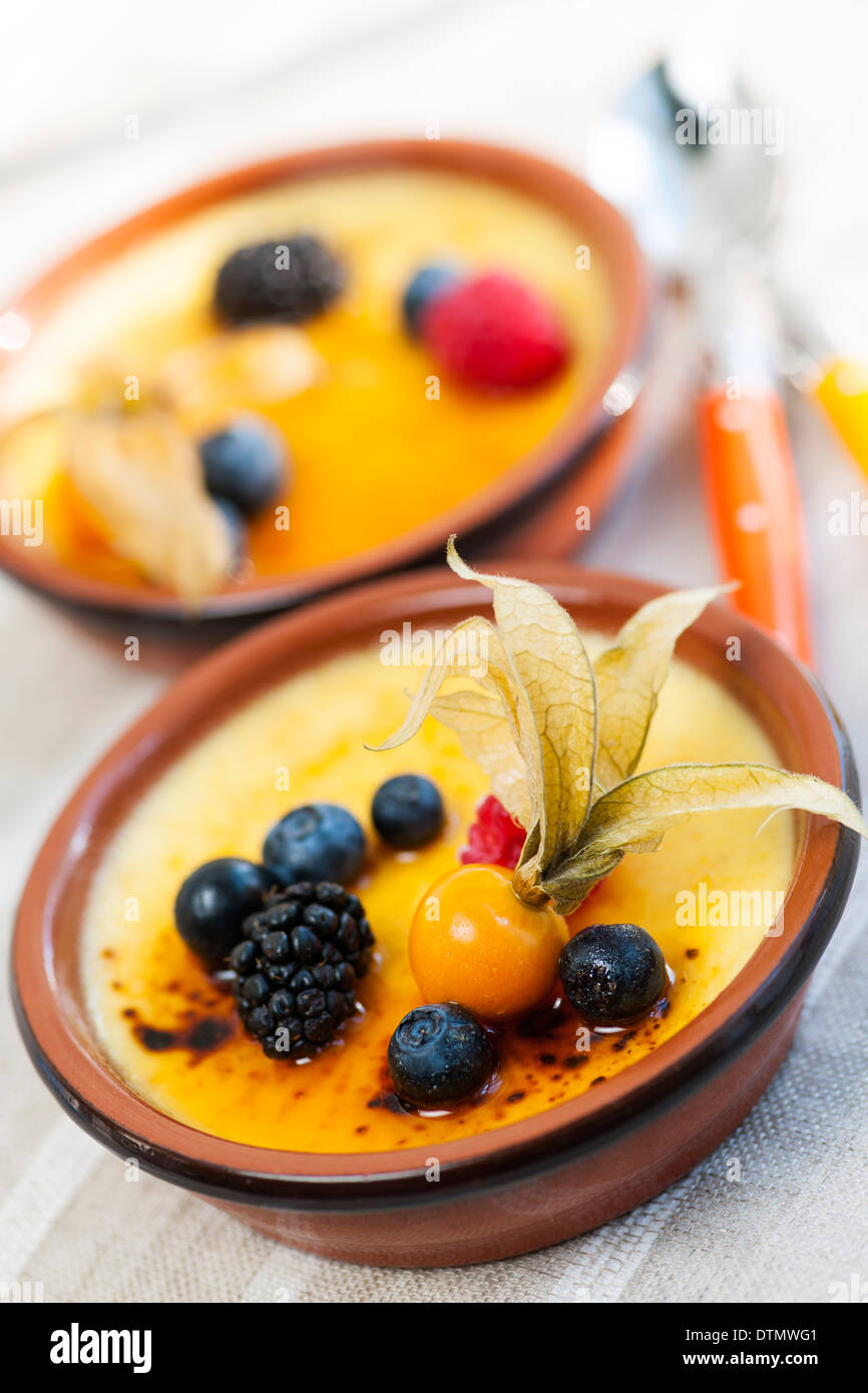 Dolce creme brulee dessert guarnita con frutti di bosco freschi Foto Stock