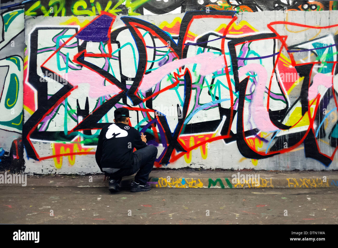 Graffiti artista al lavoro spray può pittura un muro Leake Street London SE1 Foto Stock