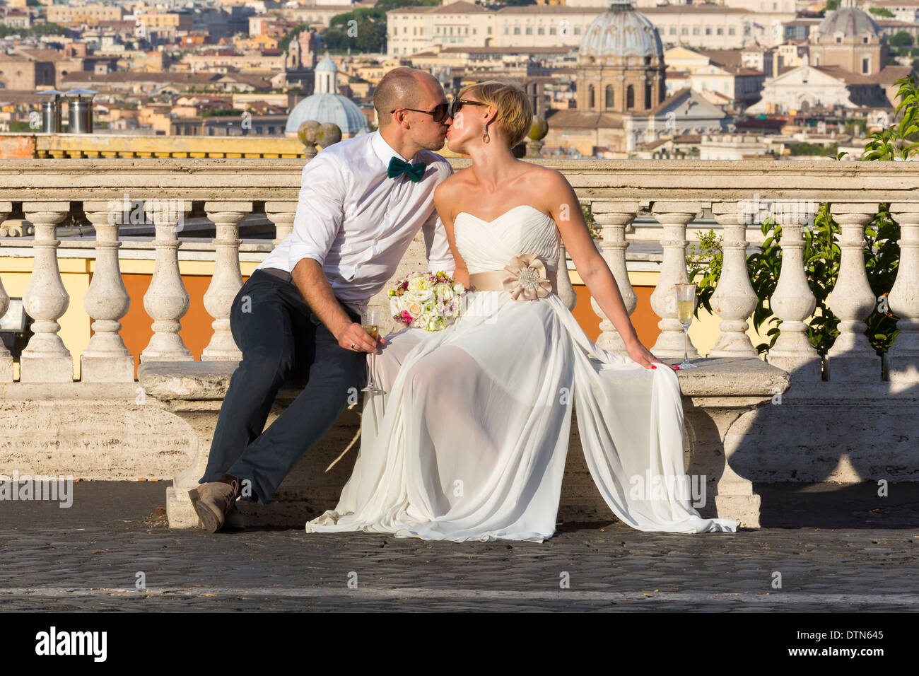 Sposi novelli kissing oltre i tetti romani Foto Stock