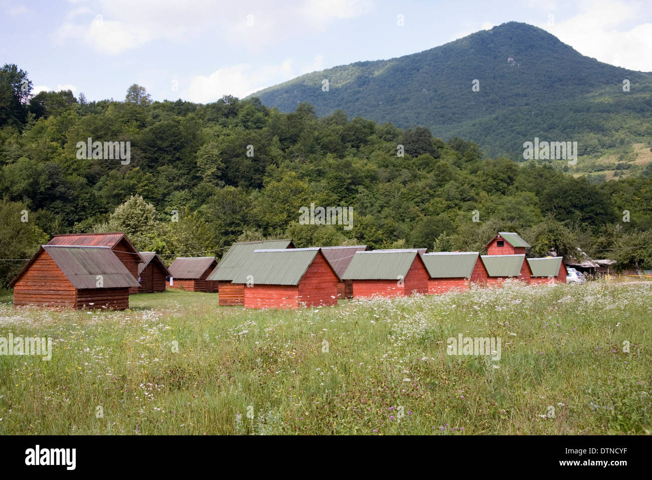 Capanne di legno in campi e montagne a Rafting Centro in Bosnia Foto Stock