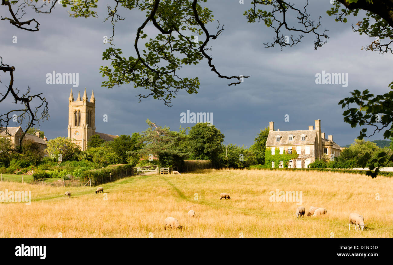 Campo rurale con vista di St Michaels chiesa e casa di Austin in Cotswolds village di Broadway, Worcestershire, Inghilterra. Foto Stock