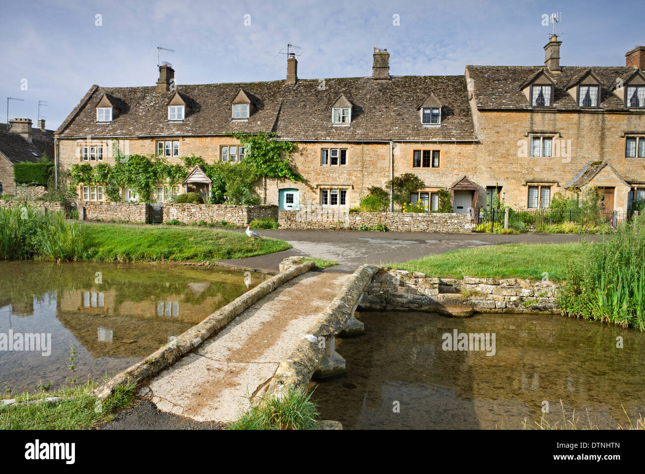 Cottages e passerella sul fiume occhio in Cotswolds village di Lower Slaughter, Gloucestershire, Inghilterra. Foto Stock