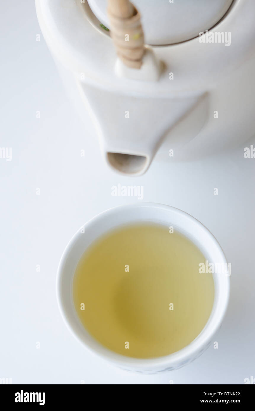 Una tazza di tè caldo con teiera bianco Foto Stock