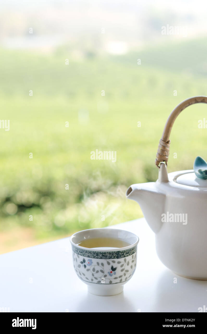 Una tazza di tè caldo con teiera bianco Foto Stock