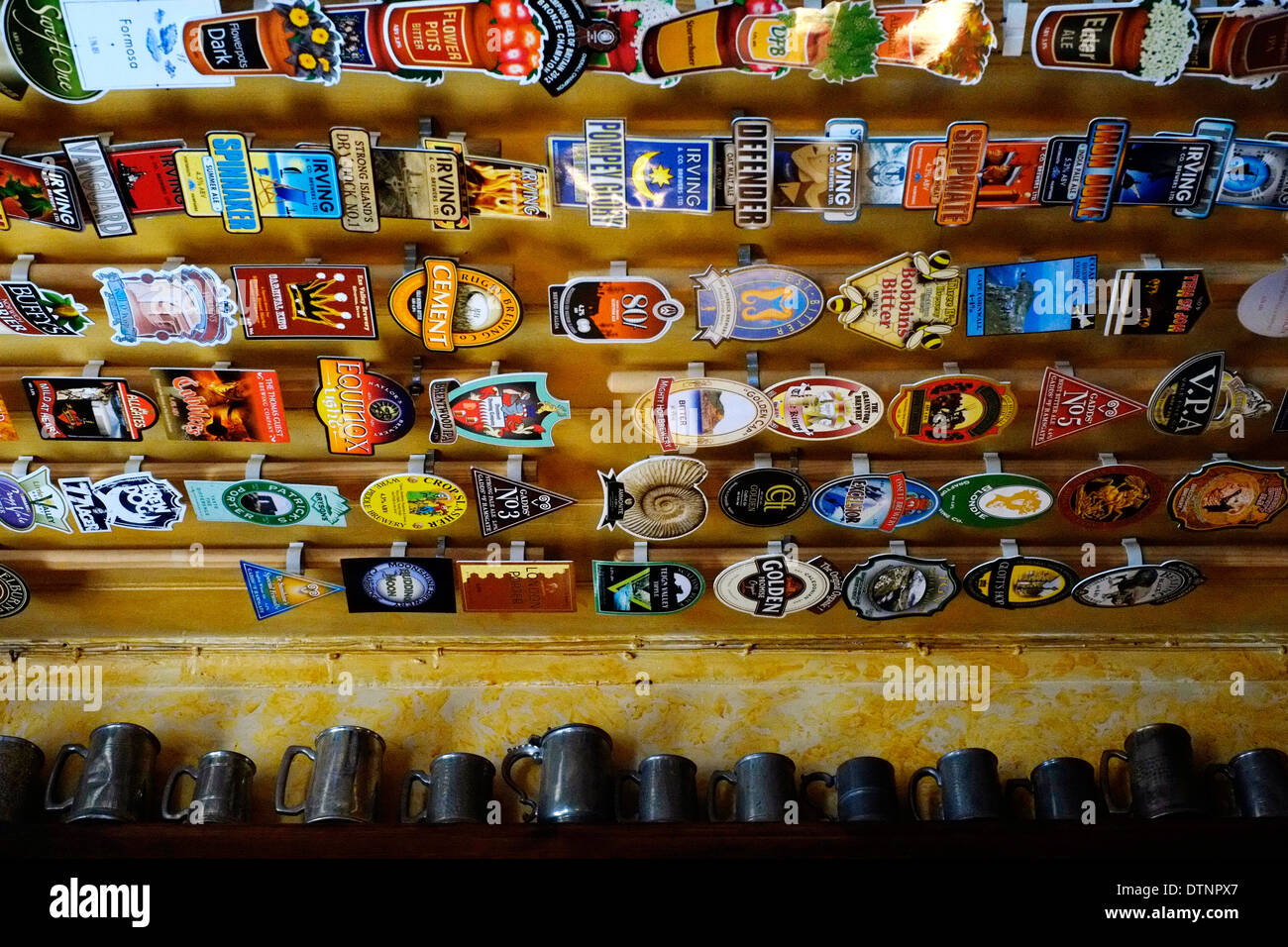 Pompa birra distintivi raffiguranti i realizzatori del nome e del marchio una linea real ale bar soffitto in corrispondenza del foro nella parete southsea England Regno Unito Foto Stock