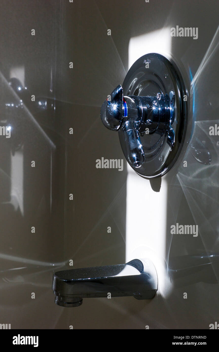 Vista astratta di diffrangere la luce del sole in una vasca di porcellana e attrezzatura di cromo Foto Stock