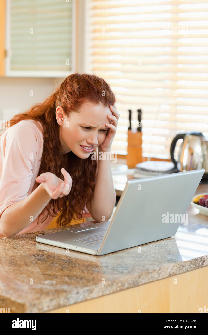 Donna che guarda irritati con il suo computer portatile Foto Stock