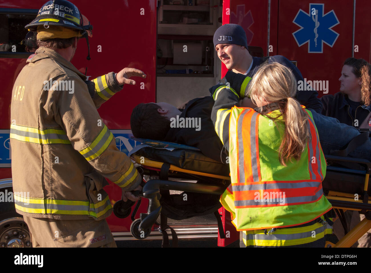 Emts caricamento di un paziente in un'ambulanza Foto Stock