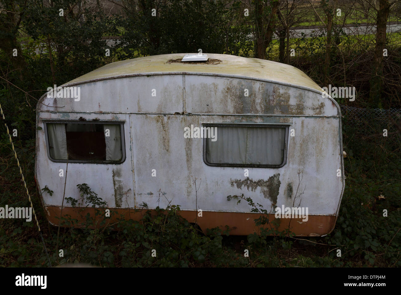 Un caravan abbandonati in seduta erbacce Foto Stock