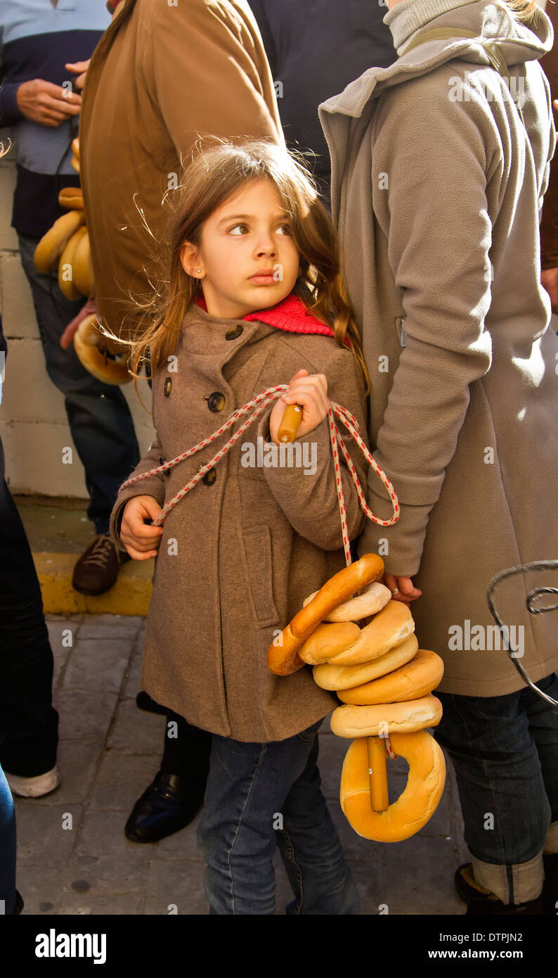 Una giovane ragazza trattiene il suo premio di fortunati pane catturati al Fiesta del Pan in balsicas, Almeria, Spagna Foto Stock