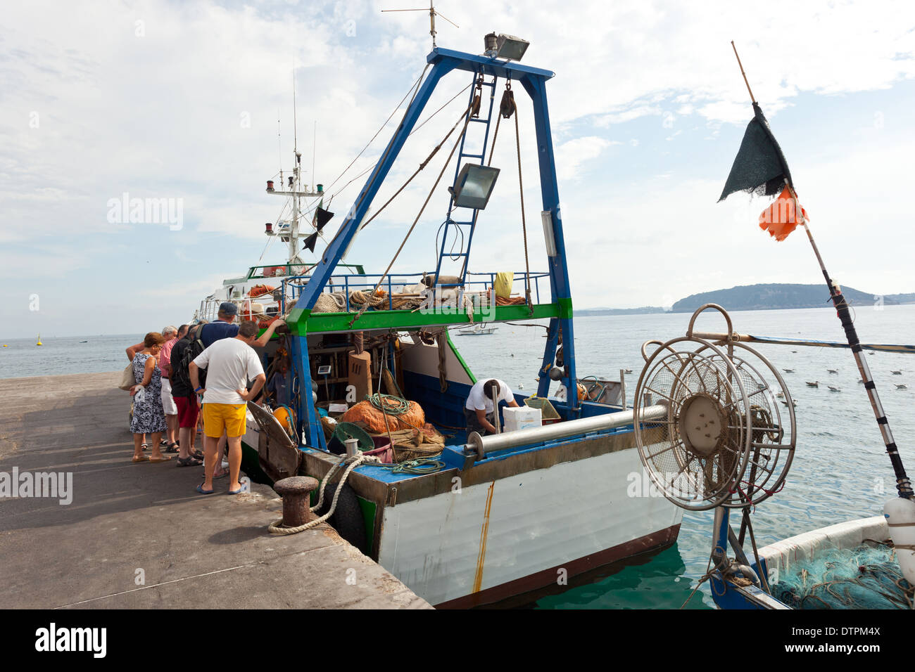 I turisti e gli operatori l'acquisto di pesce dalle barche da pesca. Isola d Ischia, Italia Foto Stock