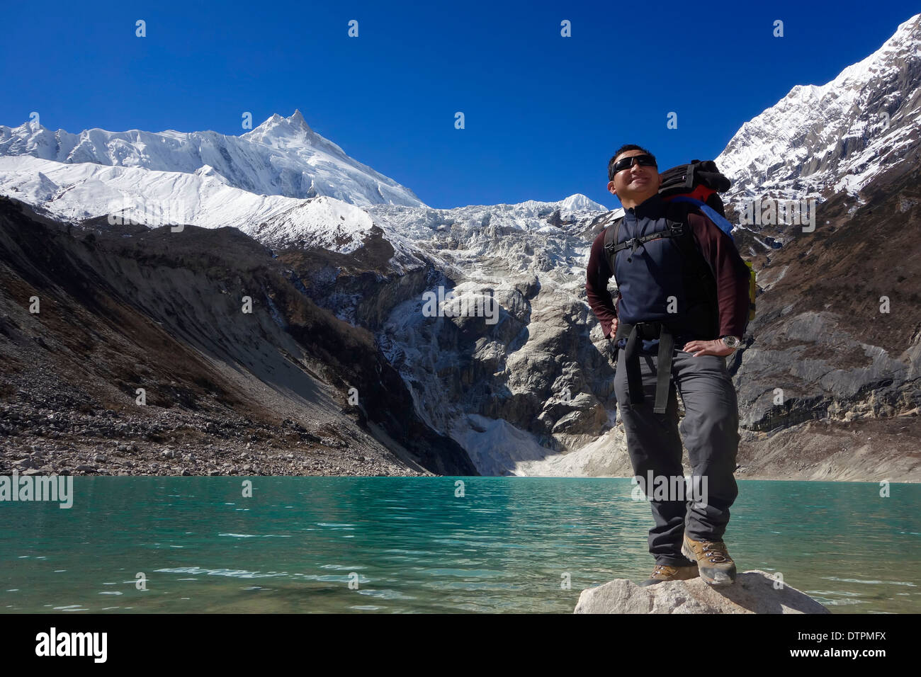 Trekker, Birendra Tal (Lago Birendra), Nepal. Il Manaslu picco è in background. Foto Stock