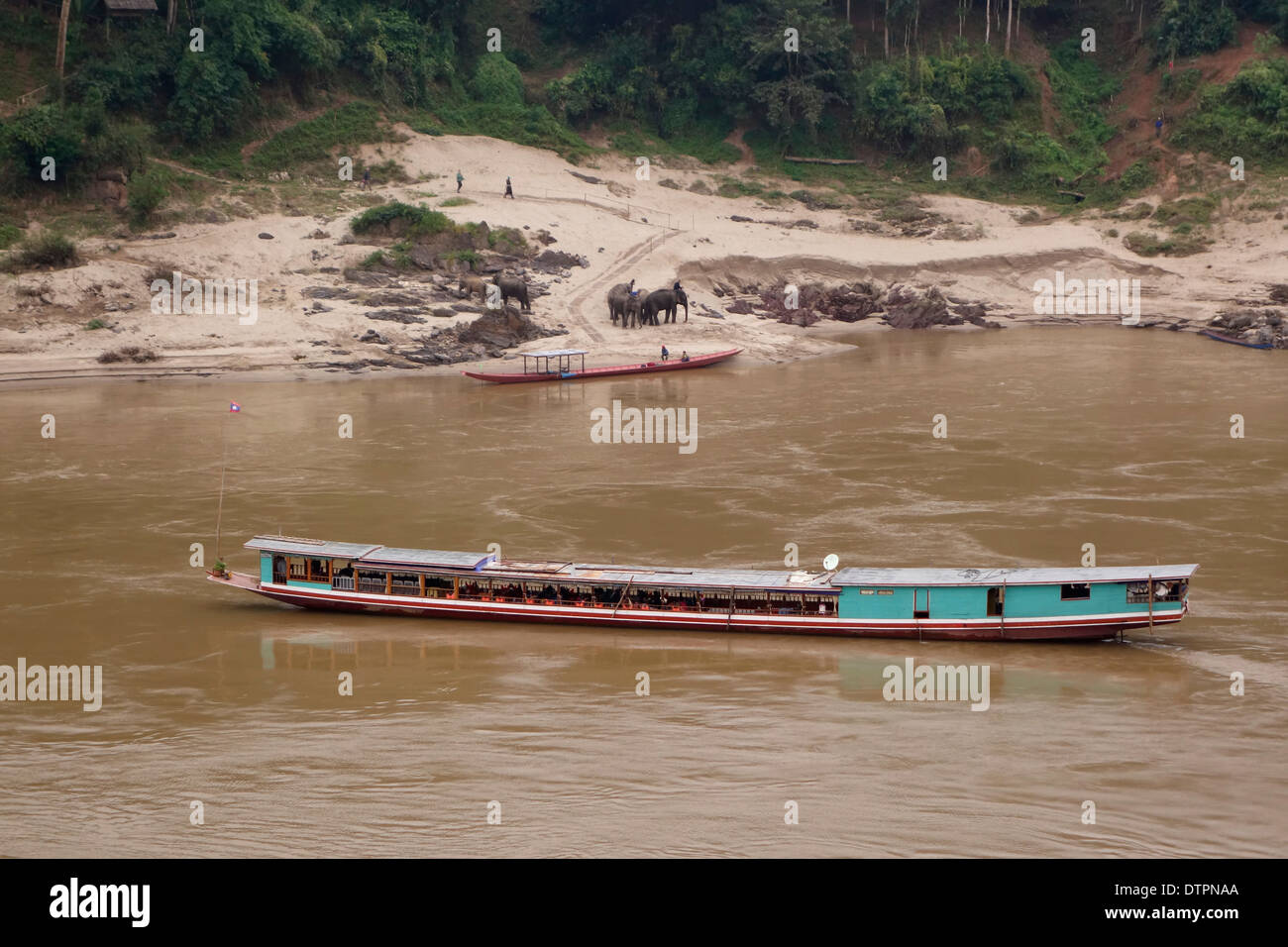 "Barca bassa"passando un elephant camp sul fiume Mekong in Laos. Foto Stock