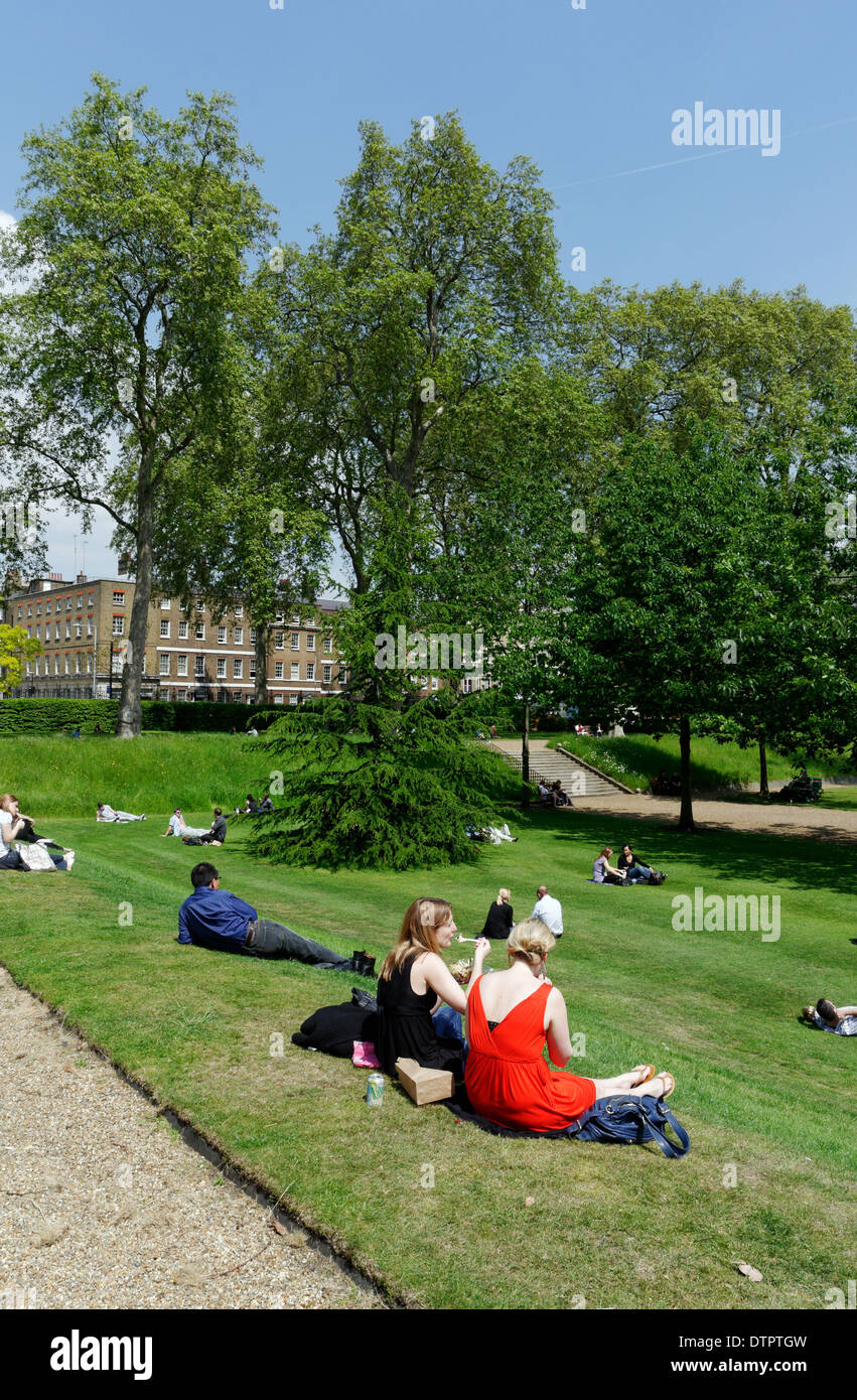 La gente seduta al sole in Gray's Inn Gardens, Londra Foto Stock