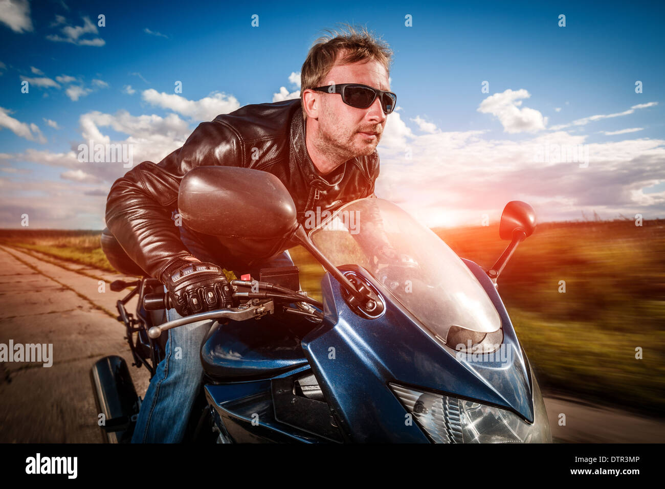 Biker in casco e giacca di pelle racing su strada Foto Stock Biker in casco e giacca di pelle racing su strada Foto Stock
