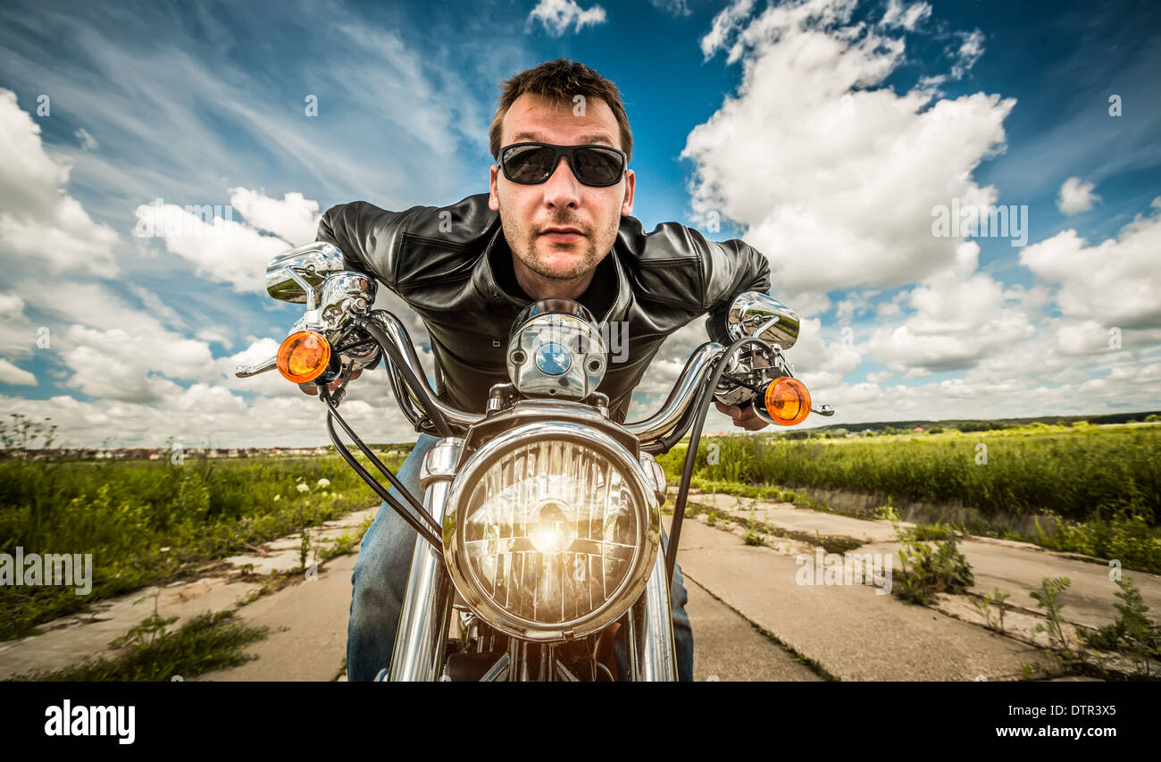 Funny Biker in occhiali da sole e giacca di pelle racing su strada (obiettivo fisheye) Foto Stock Funny Biker in occhiali da sole e giacca di pelle racing su strada (obiettivo fisheye) Foto Stock