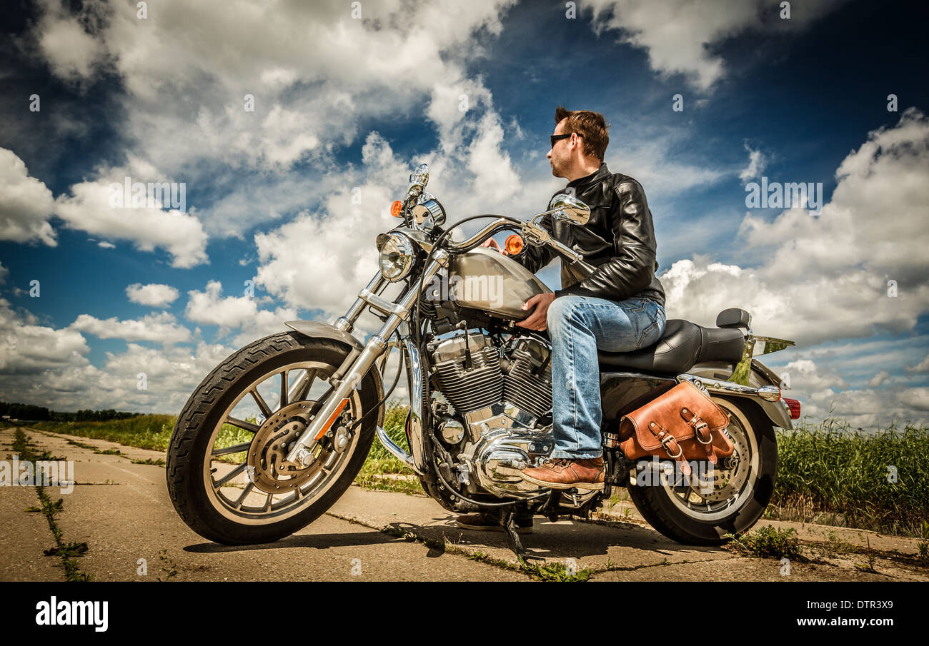 Biker in occhiali da sole e giacca di pelle sulla strada Foto Stock Biker in occhiali da sole e giacca di pelle sulla strada Foto Stock