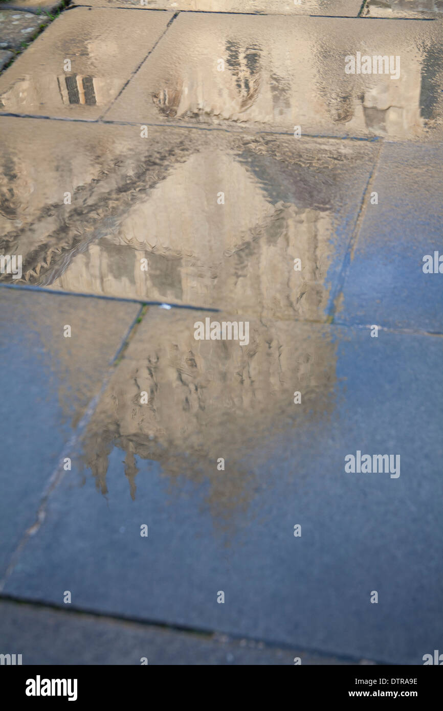 La riflessione in wet pavimentazione della Cattedrale di Wells, Somerset, Inghilterra, Regno Unito Foto Stock