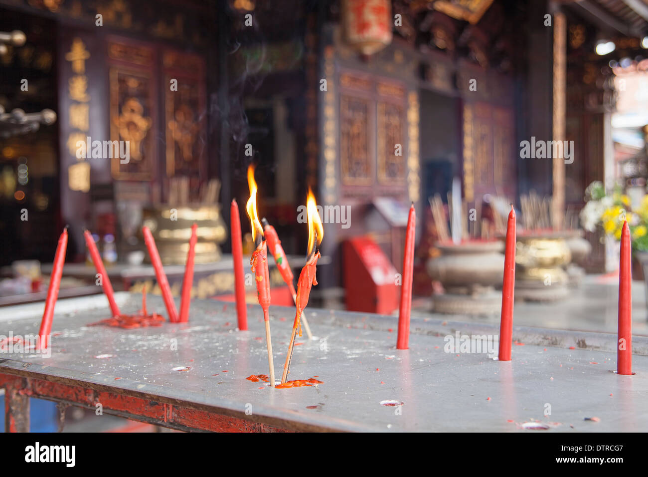 La masterizzazione di candele rosse come offerte alla divinità Cinese presso il tempio Cinese in Malacca Malaysia Foto Stock