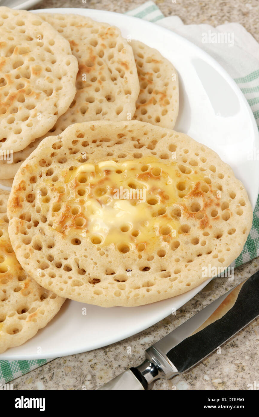 Hot pikelets imburrato una variazione regionale della tradizionale crumpet Foto Stock