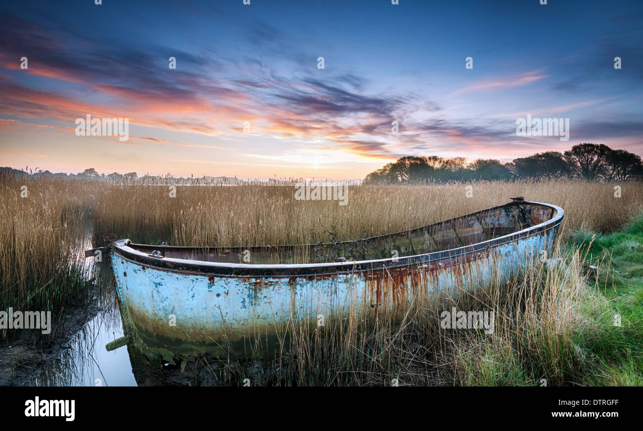 Tramonto su una nave naufragata nelle lagune del porto di Poole nel Dorset Foto Stock