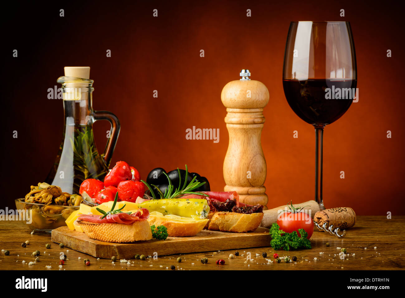 Ancora in vita con gourmet spuntini mediterranei e un bicchiere di vino rosso Foto Stock