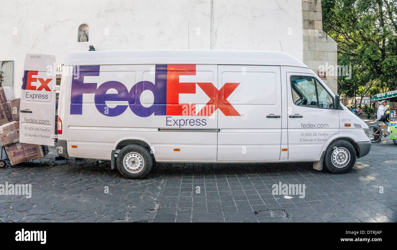 Grande ed elegante carrello Fedex rendendo consegna su Avenida Miguel Hidalgo pavimentata con ciottoli in angolo nordest di Zocalo Oaxaca Foto Stock