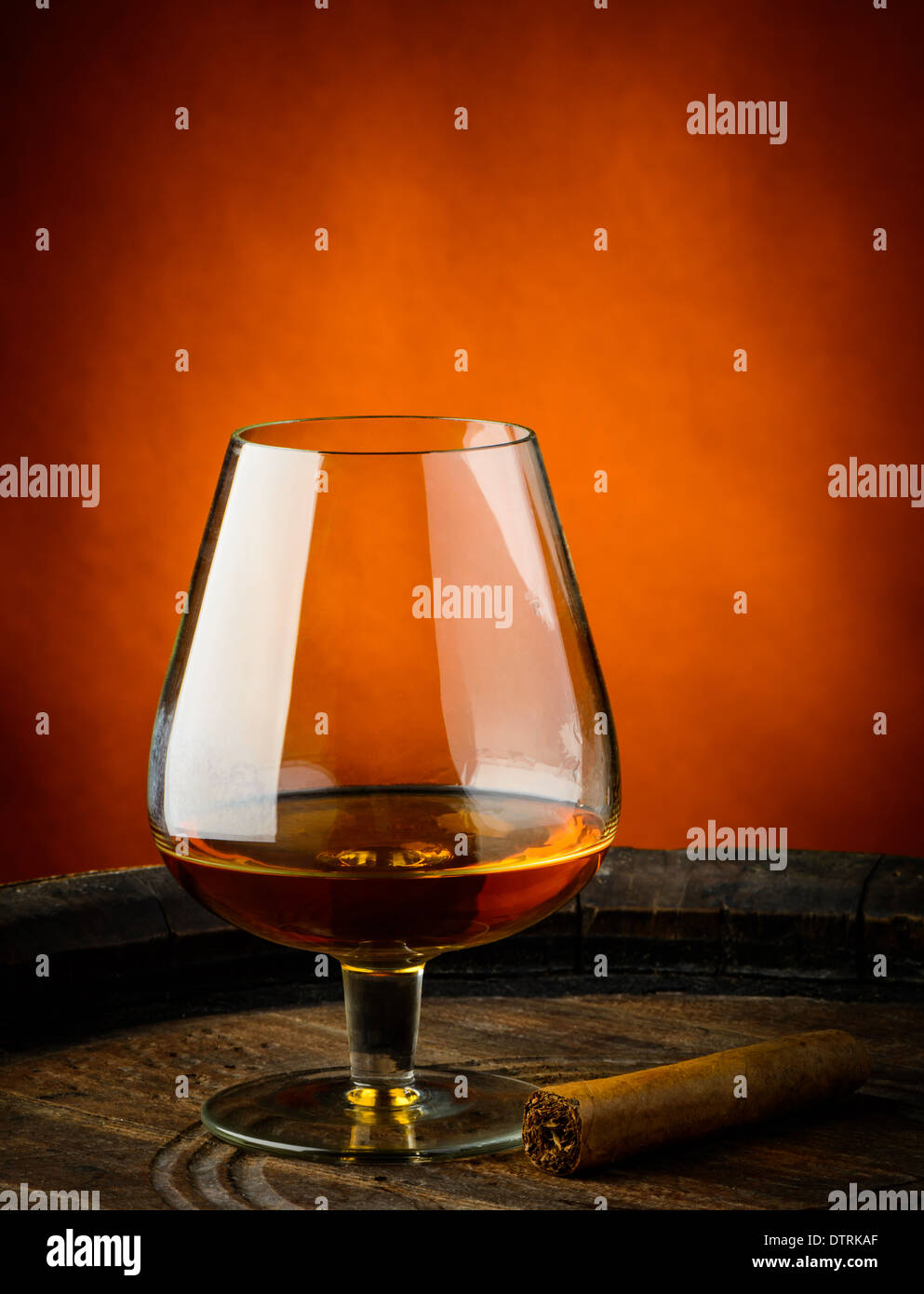 Natura morta con un bicchiere di cognac e sigari su un barile di legno Foto Stock