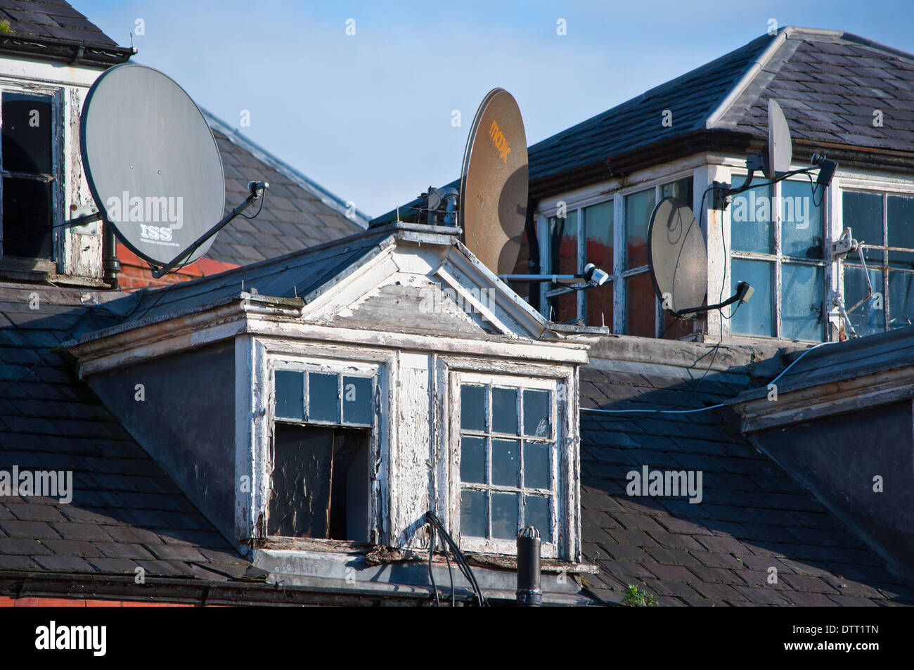 Antenne paraboliche piatto sul vecchio edificio tetto Foto Stock