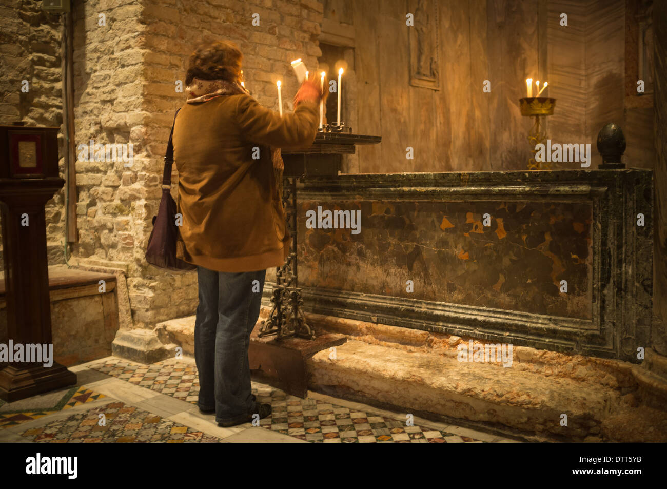 Una donna il culto delle luci di candele. La Basilica di San Marco. Venezia. Veneto. Italia Foto Stock