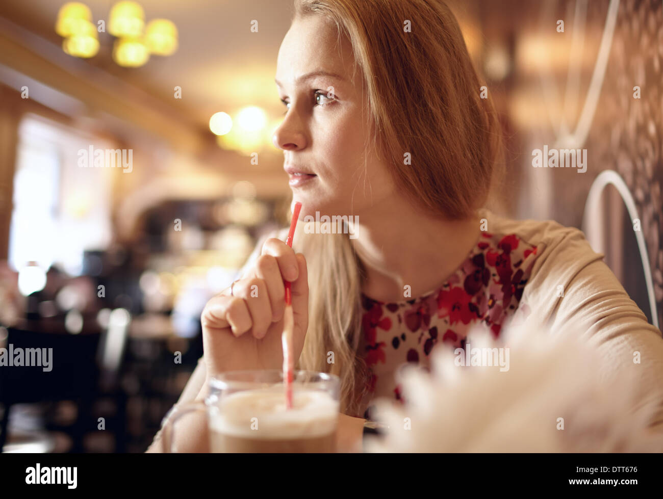 La ragazza è alla ricerca attraverso la finestra in cafe. Foto Stock