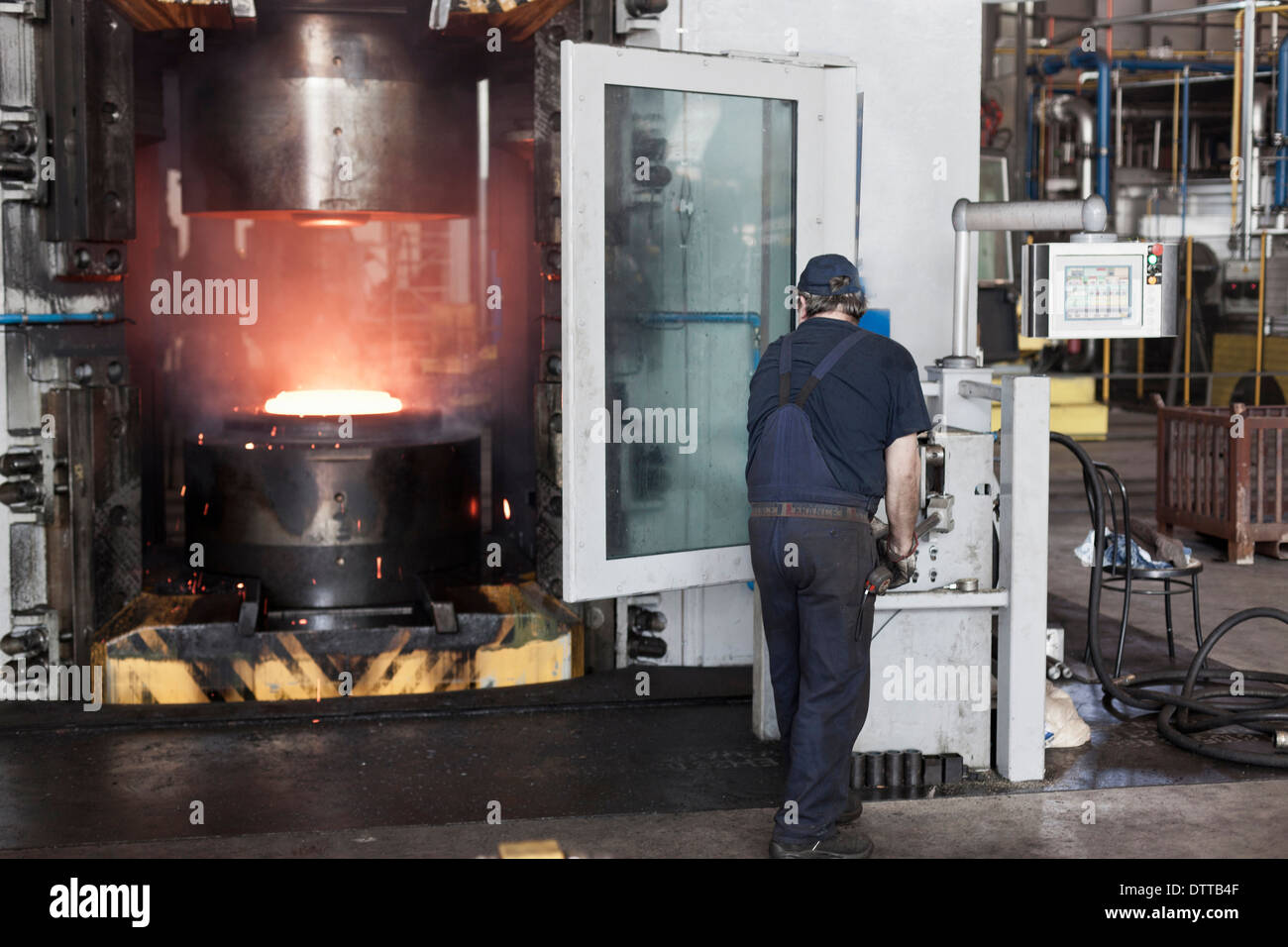 Lavoratore caucasica operanti in acciaio macchine di fusione in fabbrica Foto Stock