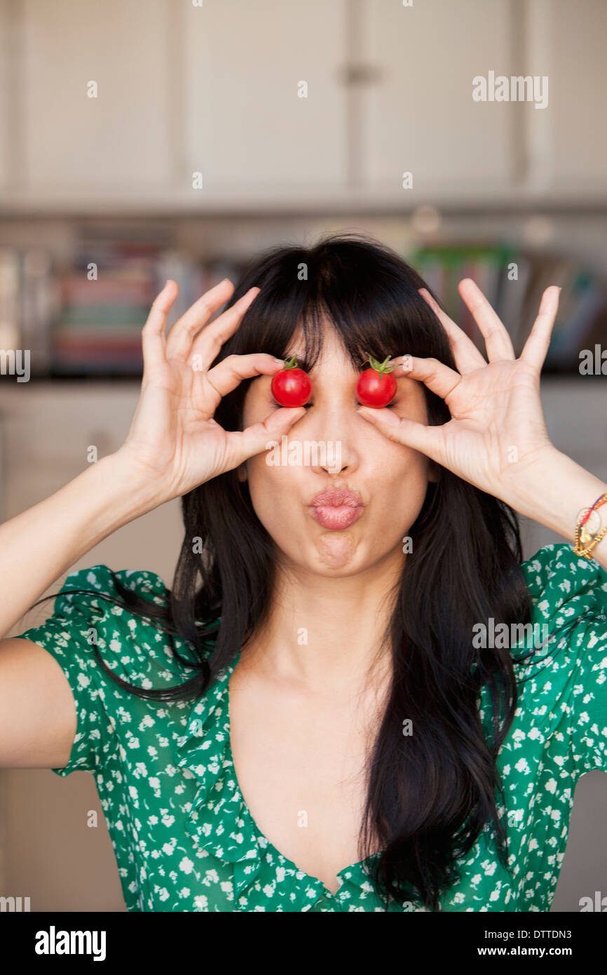 Donna che gioca con i pomodori Foto Stock