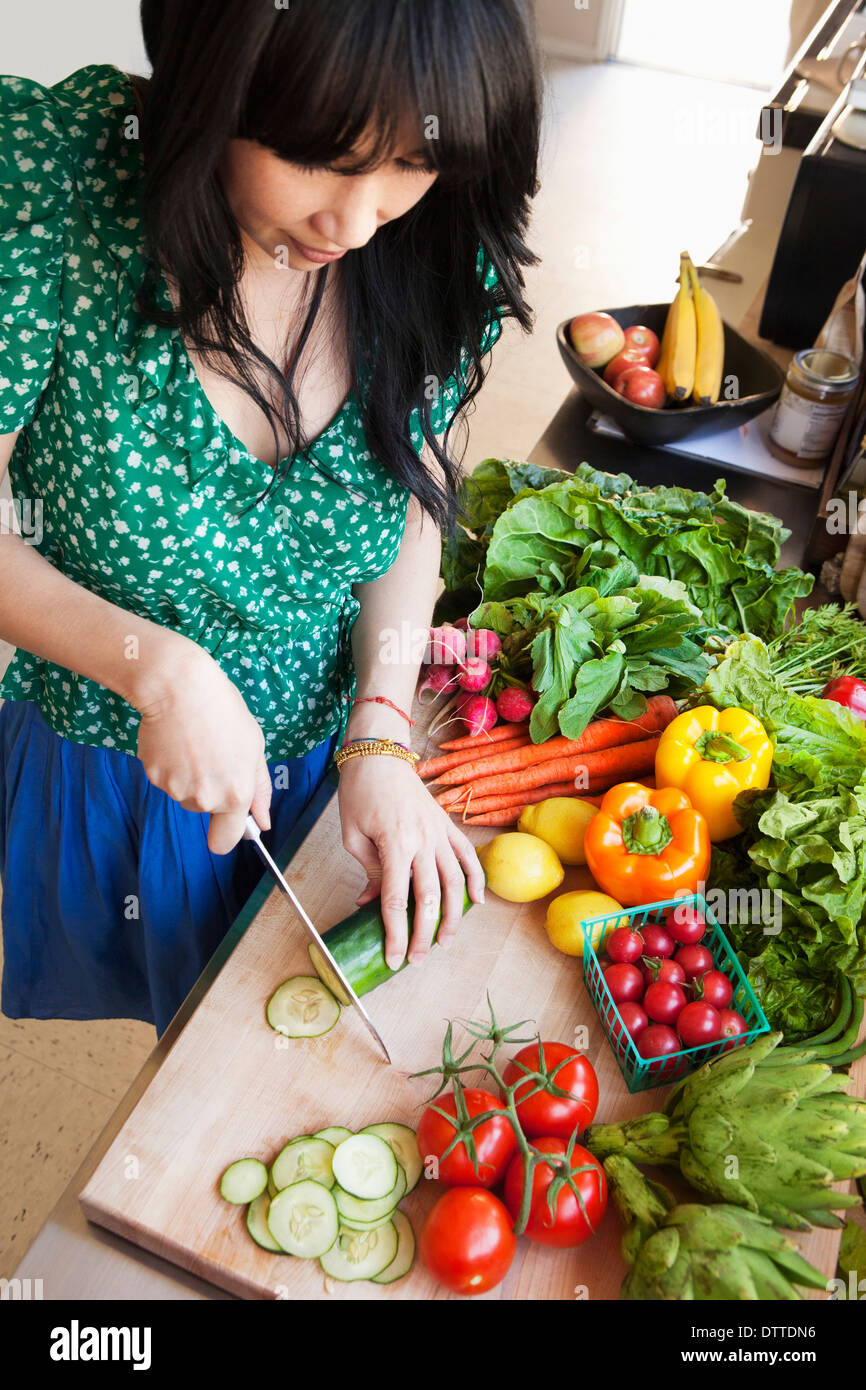 Donna tritare verdure in cucina Foto Stock