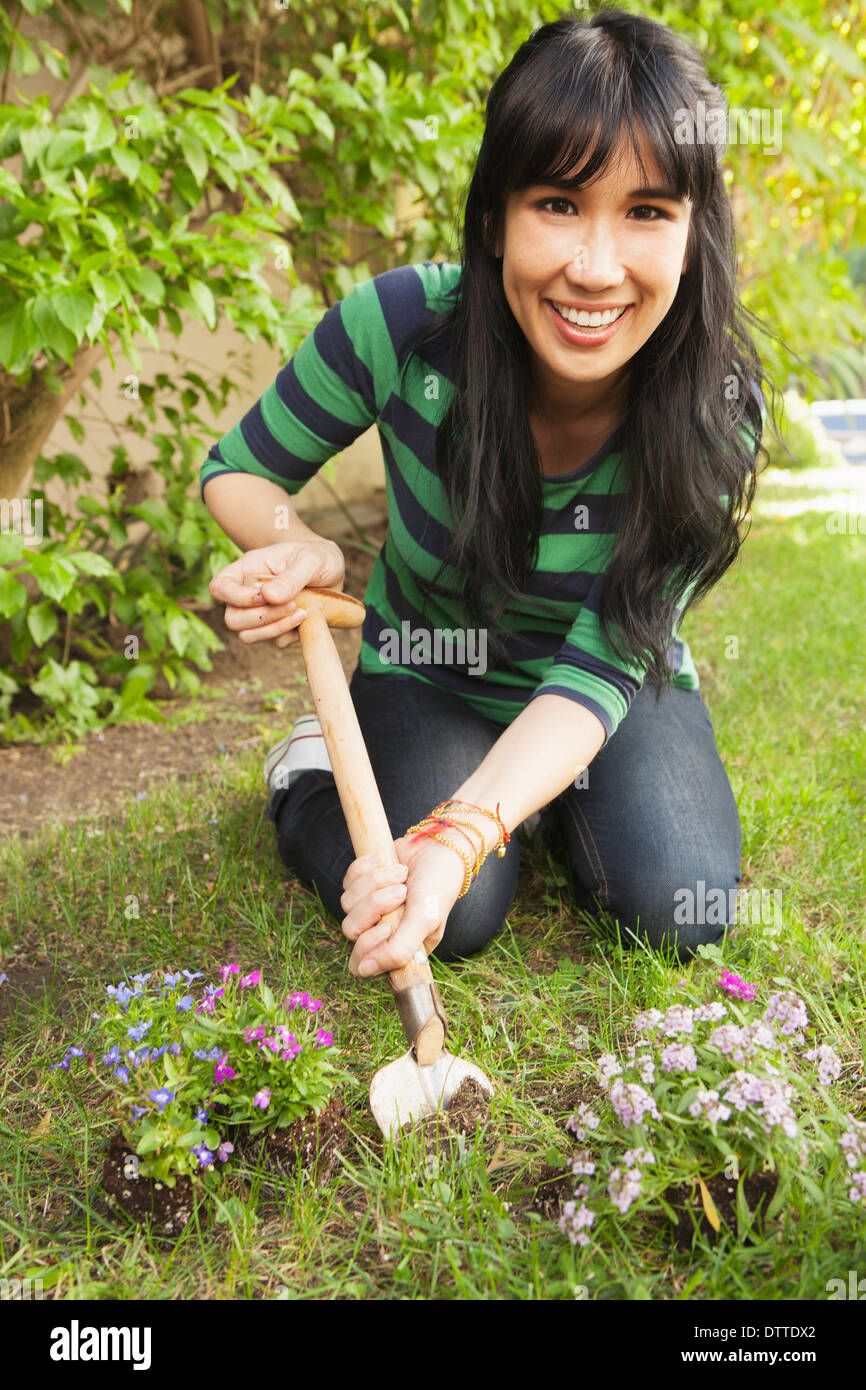 Donna piantare fiori all'aperto Foto Stock