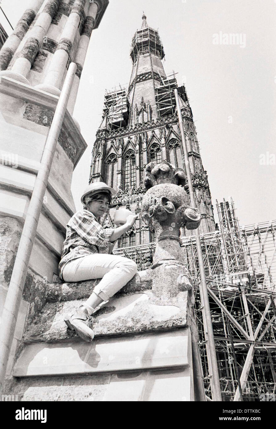 Una femmina di scalpellino ottiene di lavorare su un pinnacolo sulla facciata ovest della cattedrale di Salisbury nel 1990. Foto Stock
