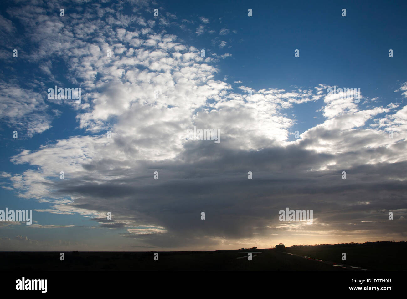 Frontale di nuvole che si muovono oltre il cielo bloccando il sole a Bawdsey, Suffolk, Inghilterra Foto Stock