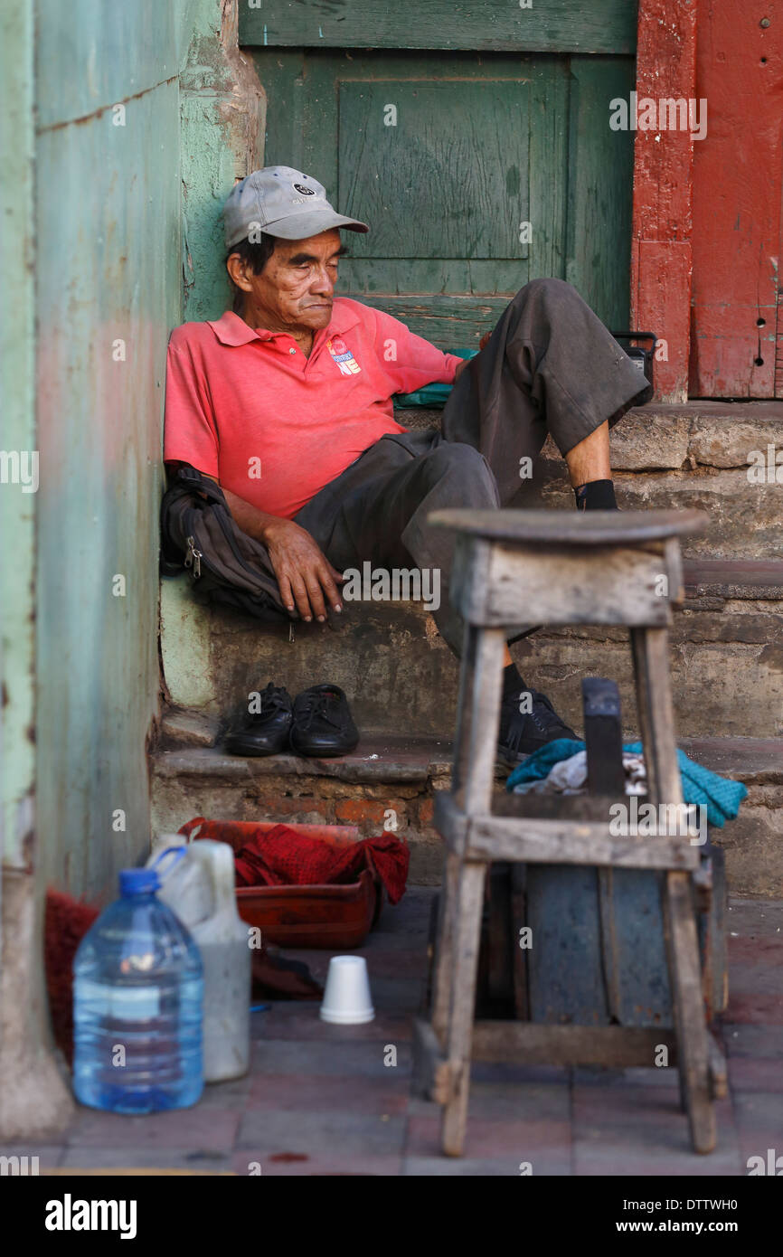 Lustrascarpe uomo in attesa per i clienti, il Mercado Municipal, Granada, Nicaragua Foto Stock